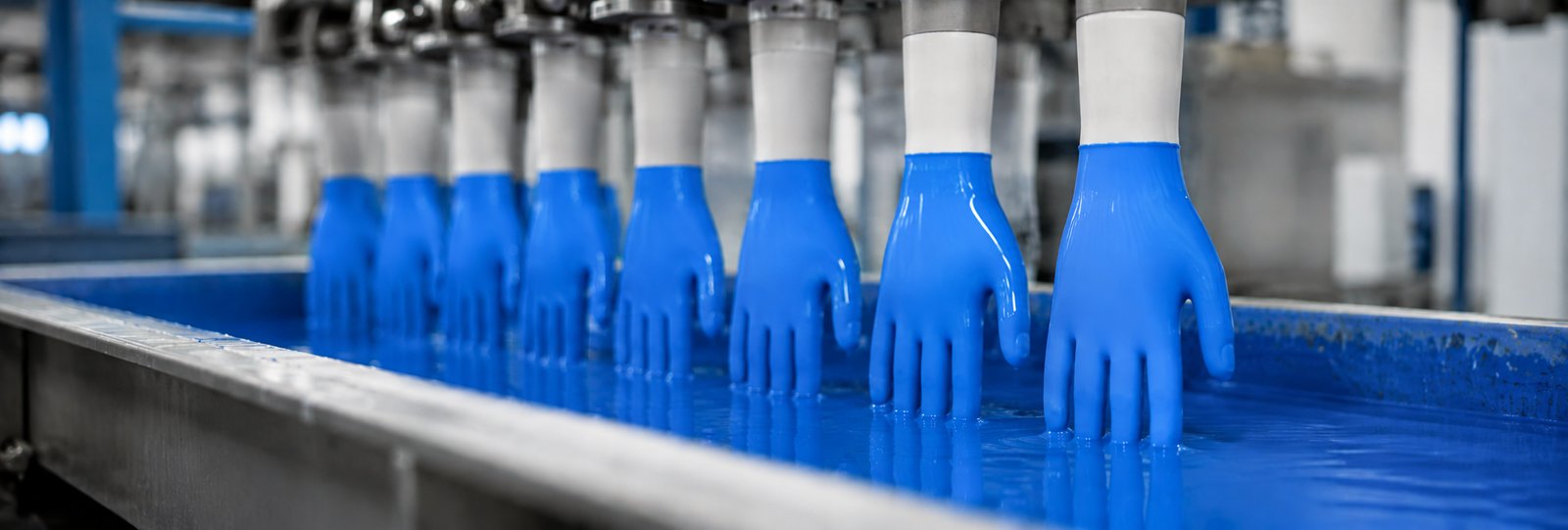 Formers with blue NBR gloves in a latex dipping tank